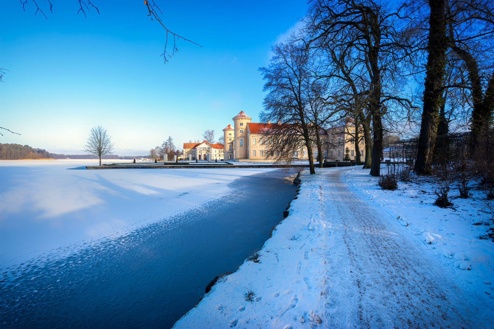 Verschneite Seepromenade mit Blick auf den zugefrorenen See