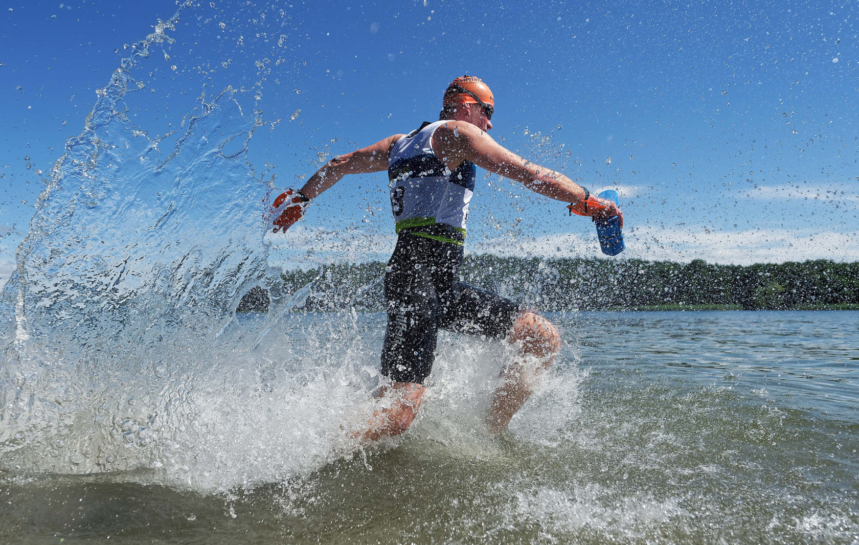 Sportler vom SwimRun sprintet in das Wasser