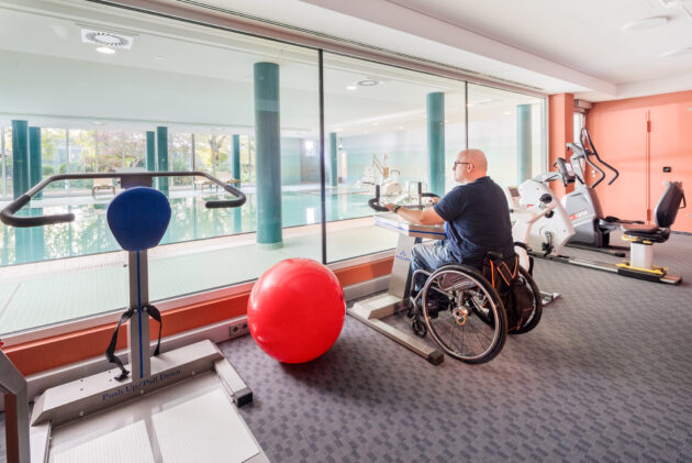 Ein Rollstuhlfaher trainiert im Fitnessraum